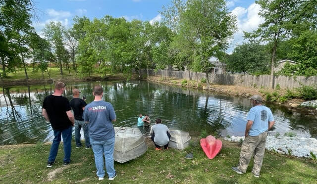 Residents and staff gather around the in2Action pond to witness a resident's baptism ceremony,